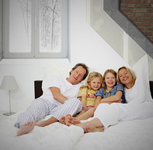 A family sitting on a bed

Description automatically generated with low confidence