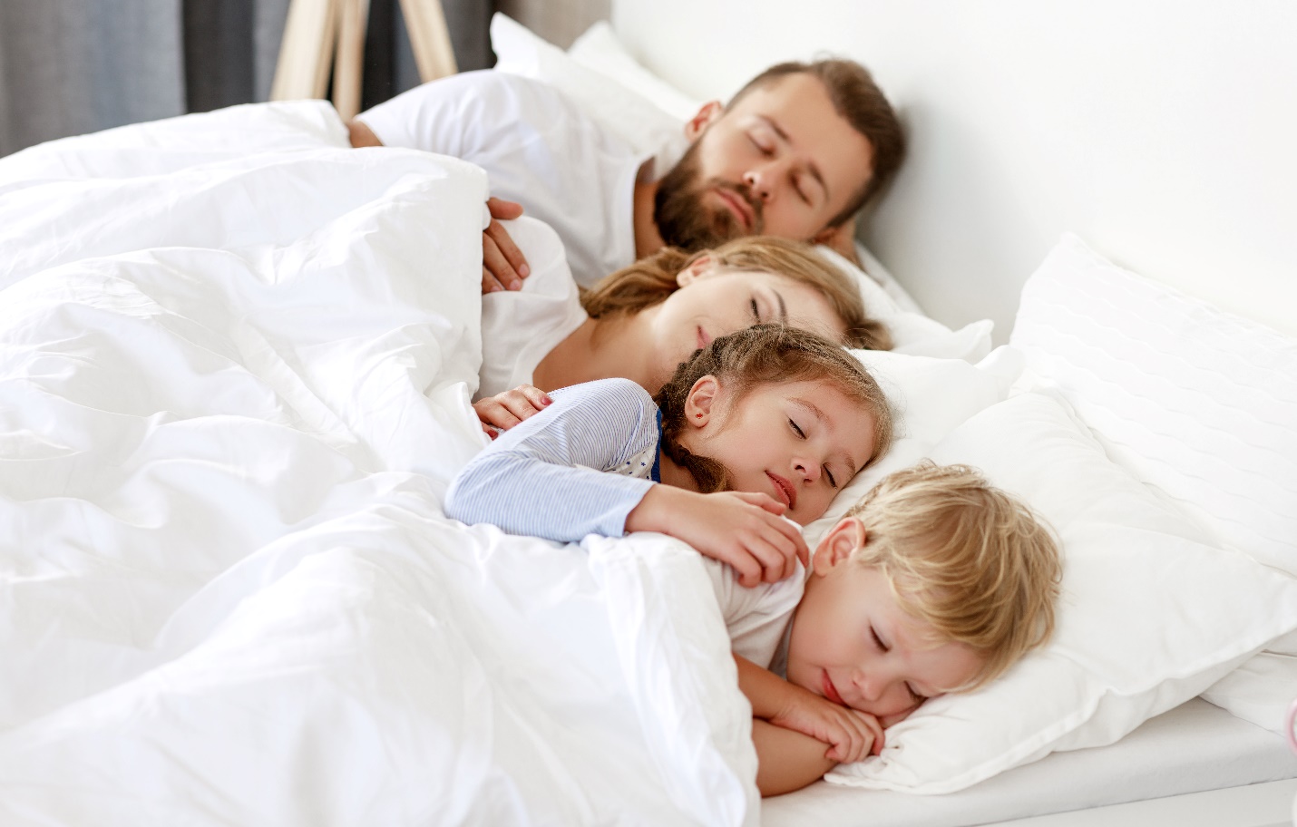 A person and two children lying in a bed

Description automatically generated with low confidence